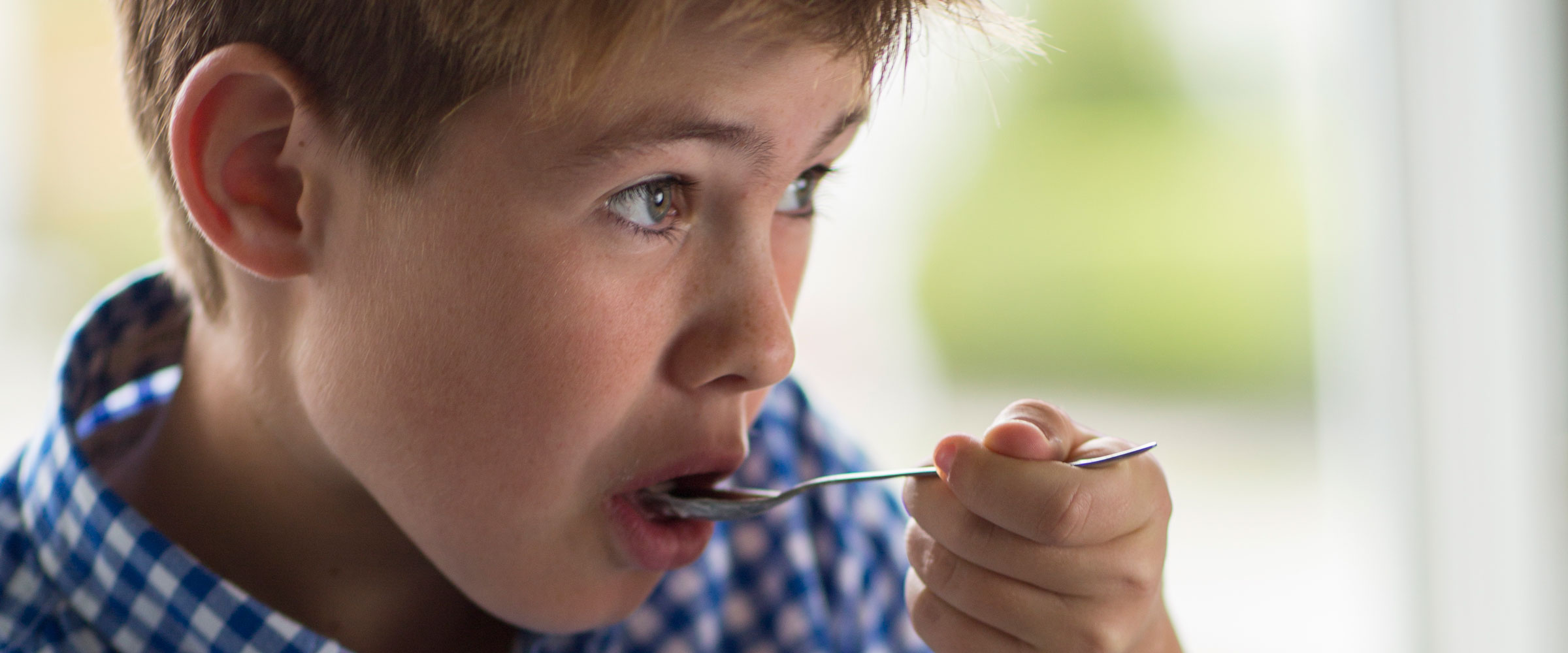 Niño comiendo yogur firme